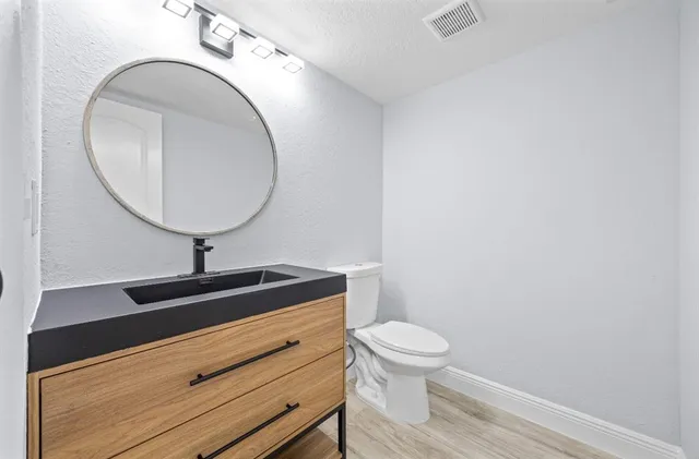 a bathroom with a toilet a sink and mirror