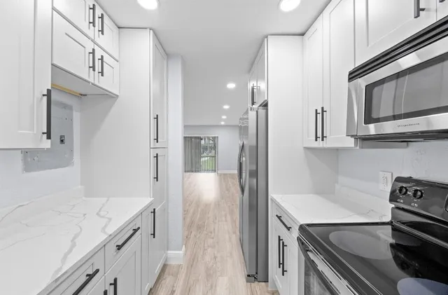 a kitchen with stainless steel appliances a stove microwave and refrigerator