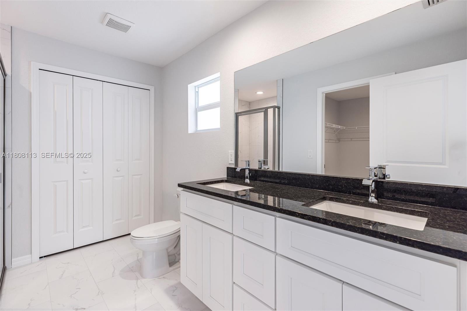 2006 Rosa Court, Unit 2006 Lehigh Acres, FL 33972 - Photo 12 of 22 a bathroom with a granite countertop sink a toilet and a mirror