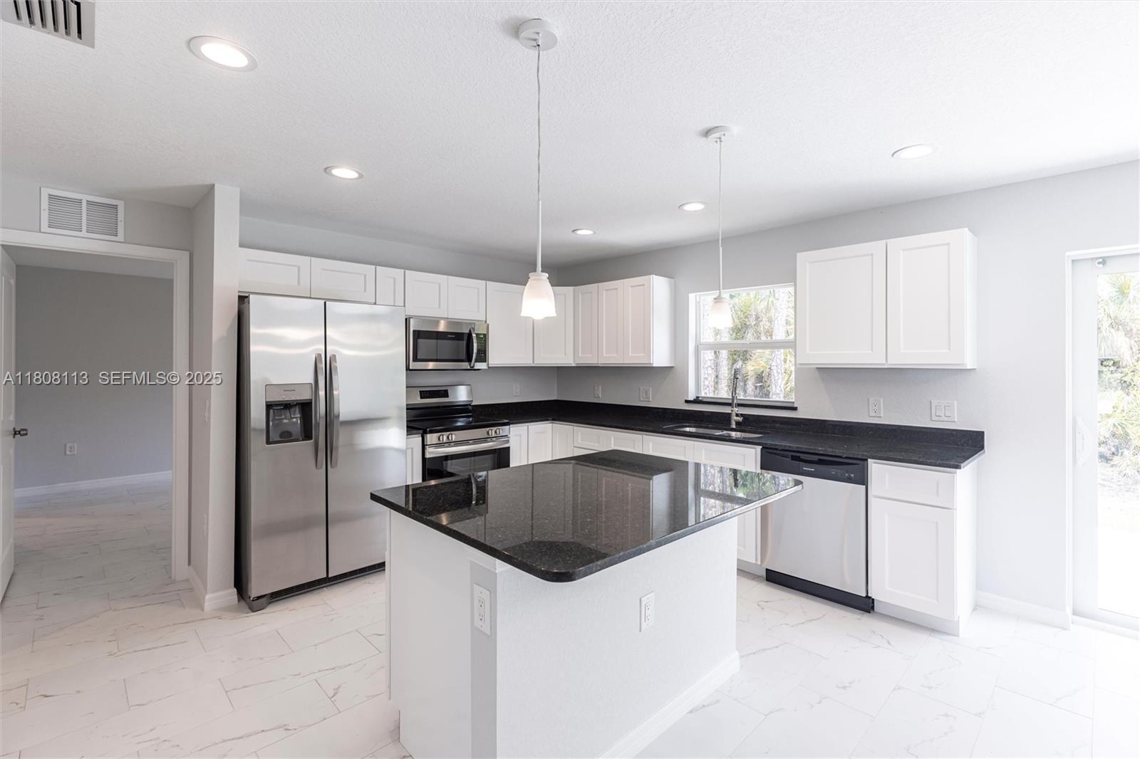 2006 Rosa Court, Unit 2006 Lehigh Acres, FL 33972 - Photo 3 of 22 a kitchen with stainless steel appliances granite countertop a sink a stove a refrigerator and island