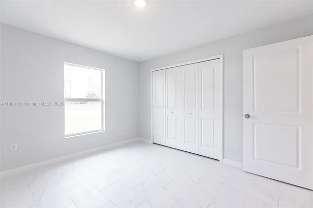 an empty room with windows and closet