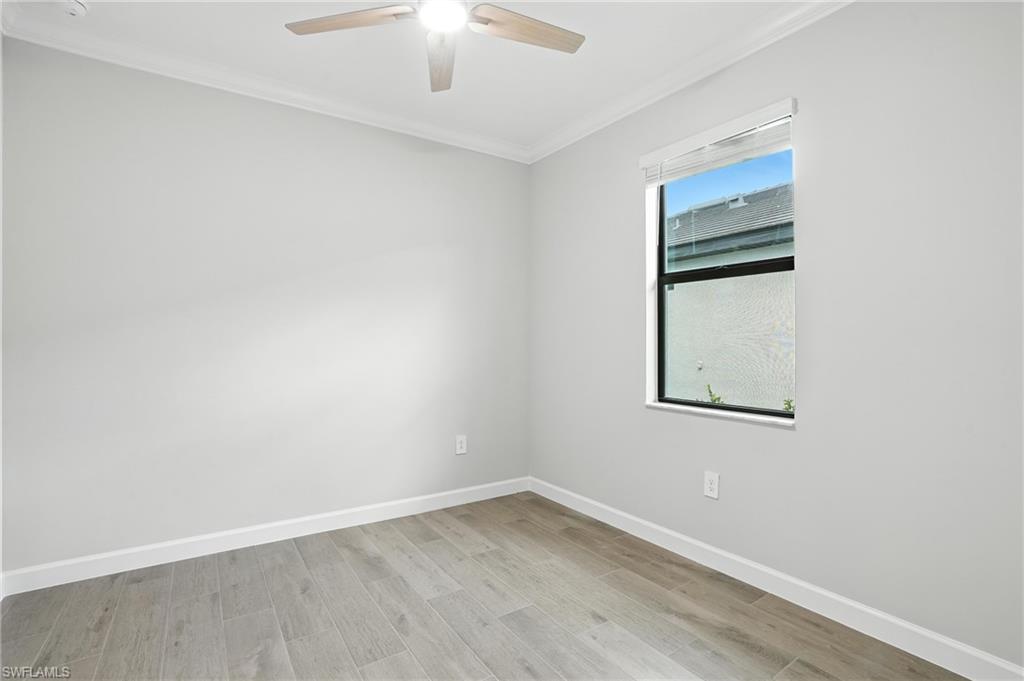 19105 Hinkley Drive Estero, FL 33928 - Photo 20 of 48 Empty room with crown molding, a ceiling fan, and wood finished floors