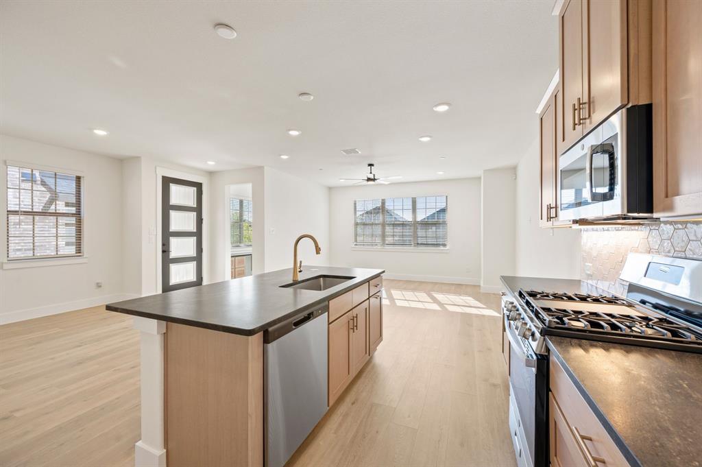 2516 Red Tailed Hawk Lane McKinney, TX 75071 - Photo 25 of 25 a kitchen with stainless steel appliances granite countertop a sink a stove and a wooden cabinets