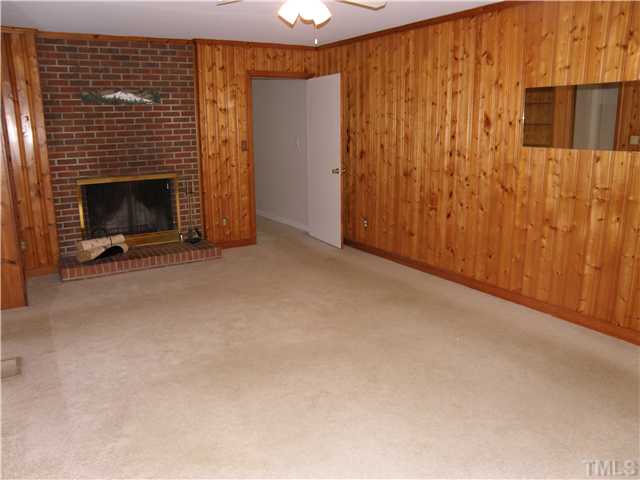 5219 Melbourne Road Raleigh, NC 27606 - Photo 4 of 21 Family room has fireplace. It has access to kitchen, hallway, bathroom and covered porch. We expect hardwoods under carpet