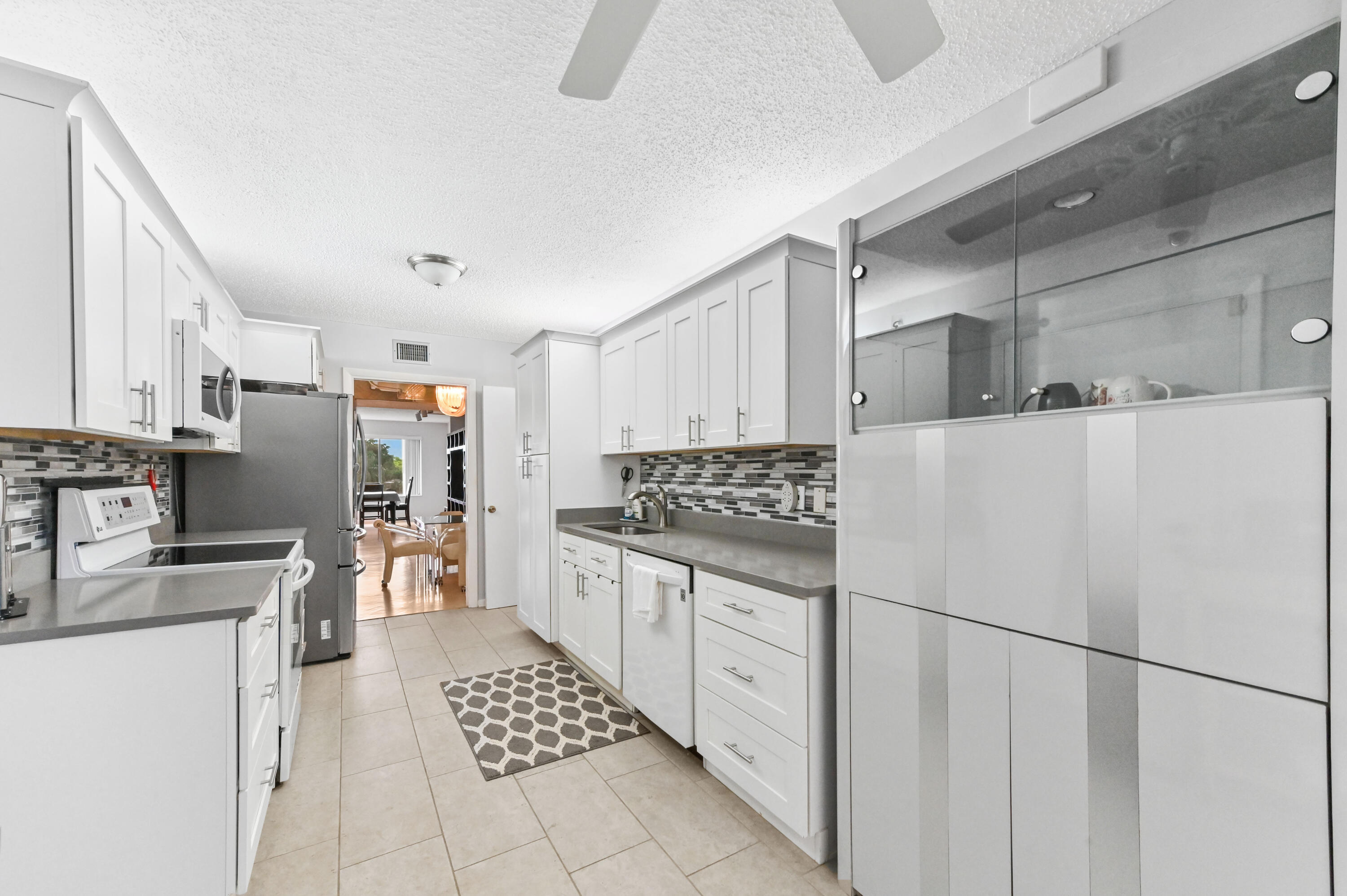 6768 10th Avenue North, Unit 316 Lake Worth, FL 33467 - Photo 11 of 38 a kitchen with stainless steel appliances a refrigerator sink and cabinets