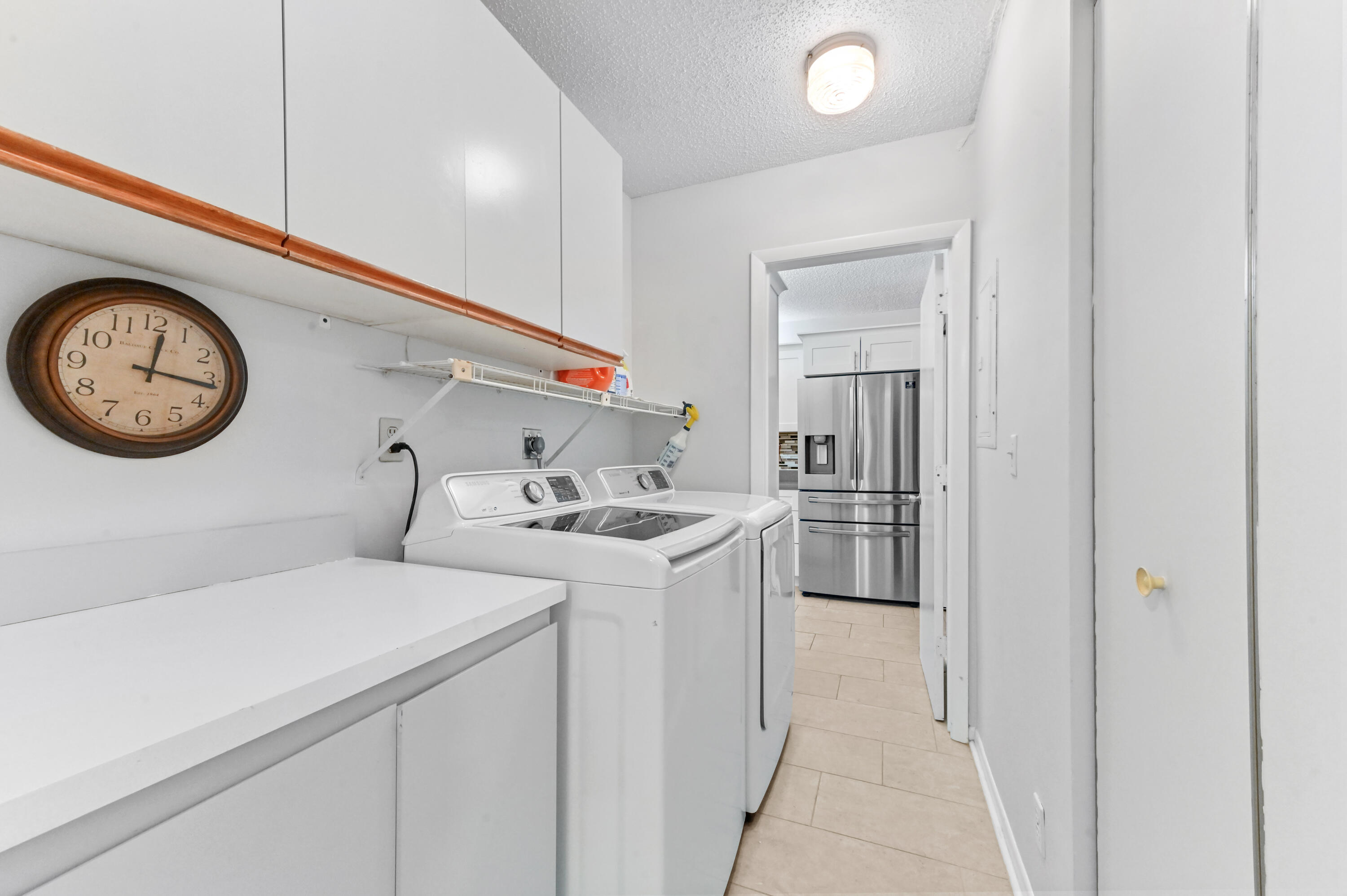6768 10th Avenue North, Unit 316 Lake Worth, FL 33467 - Photo 13 of 38 a view of a hallway with washer and a clock