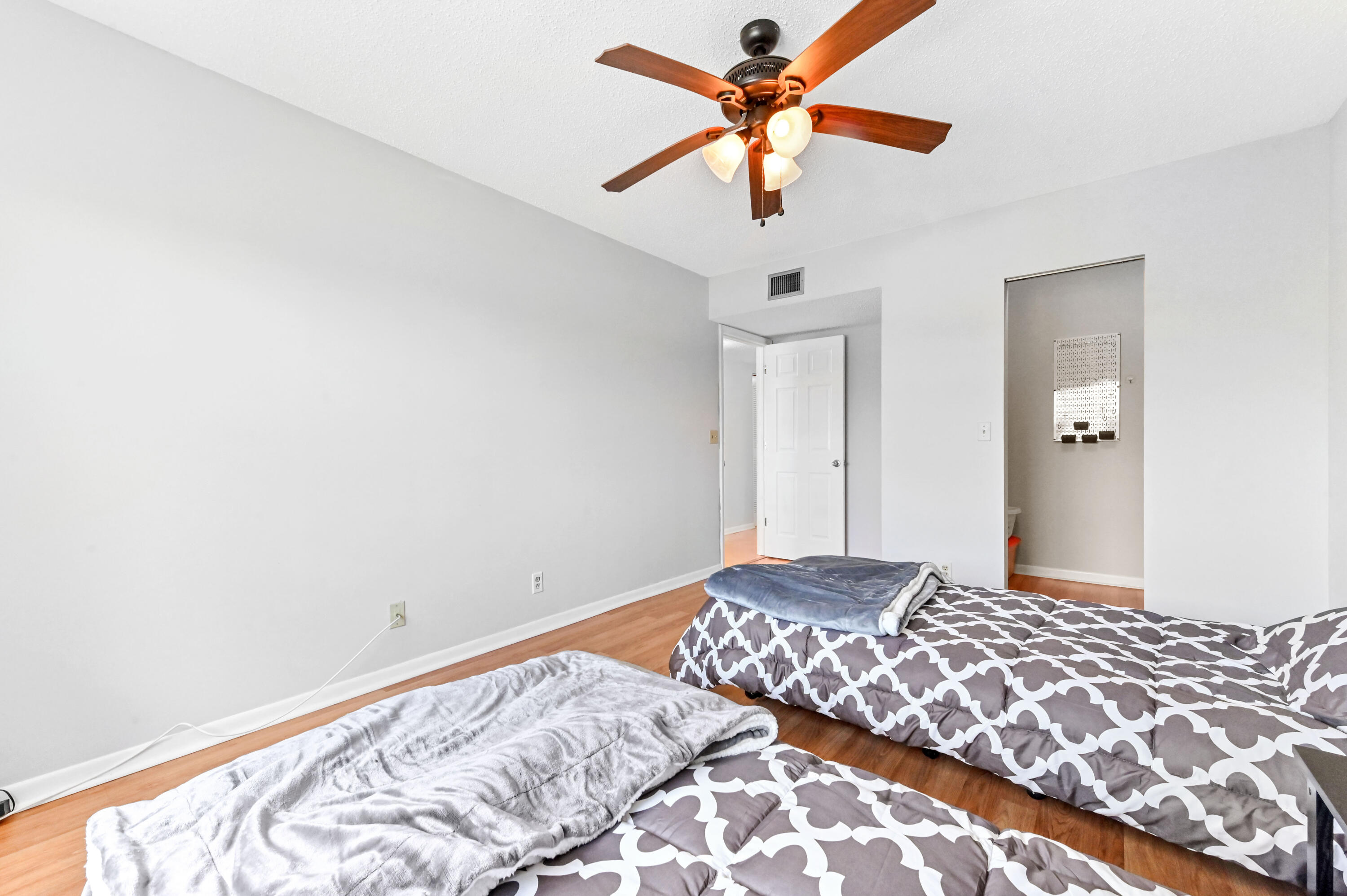 6768 10th Avenue North, Unit 316 Lake Worth, FL 33467 - Photo 19 of 38 a bedroom with a bed and a chandelier