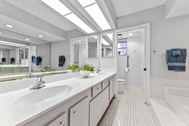 a bathroom with a double vanity sink mirror and shower