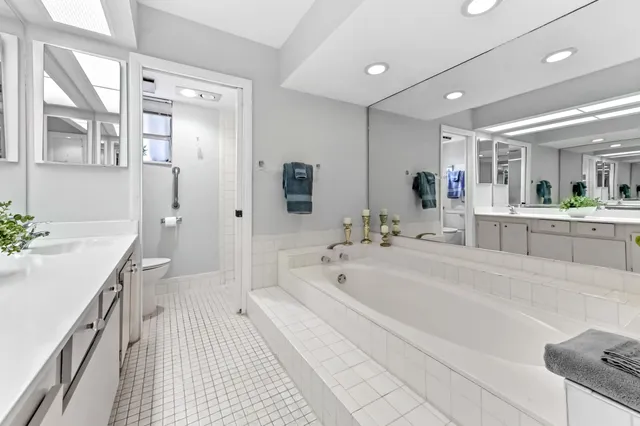 a spacious bathroom with a tub sink shower and mirror