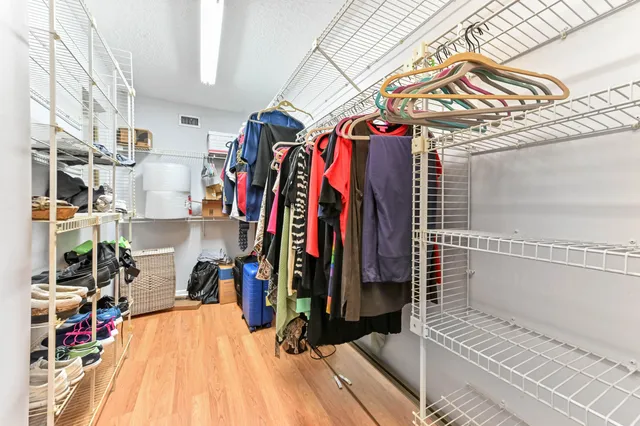 a view of walk in closet with clothes and shoes