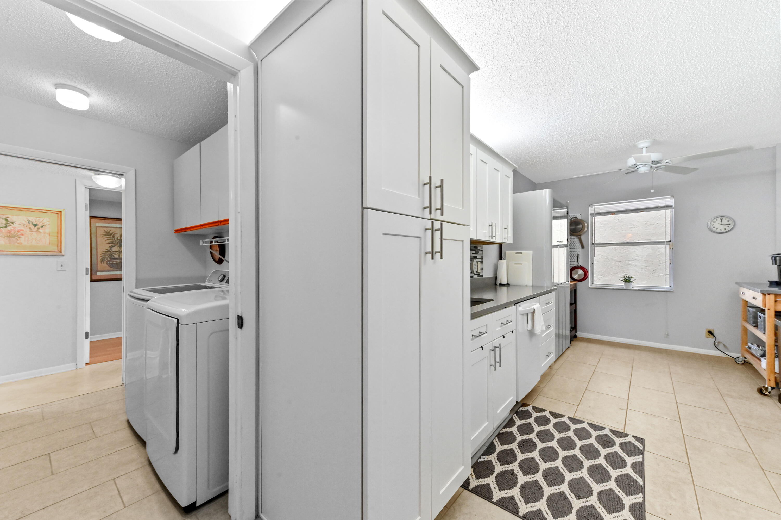 6768 10th Avenue North, Unit 316 Lake Worth, FL 33467 - Photo 9 of 38 a kitchen with a refrigerator and white cabinets