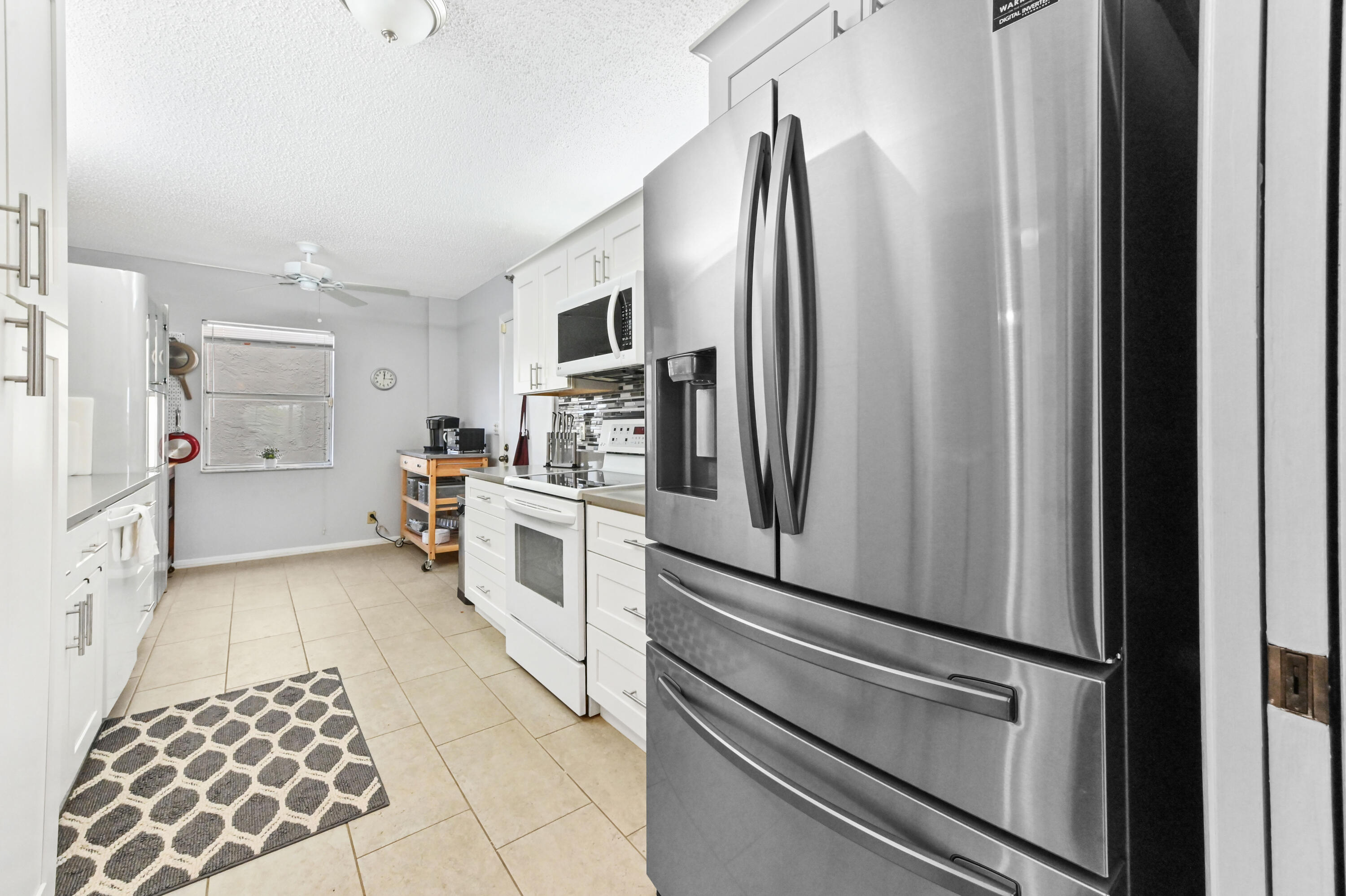 6768 10th Avenue North, Unit 316 Lake Worth, FL 33467 - Photo 10 of 38 a kitchen with stainless steel appliances a refrigerator and cabinets