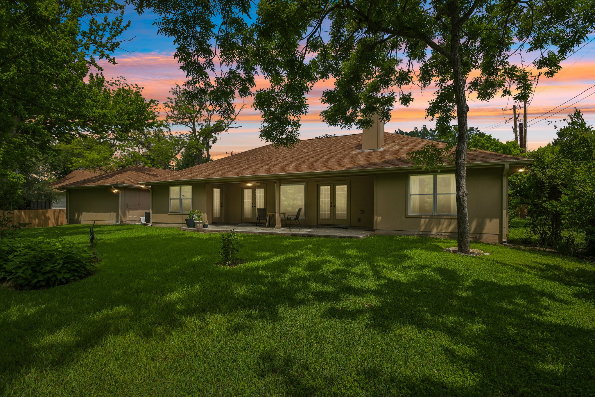307 West 4th Street Elgin, TX 78621 - Photo 37 of 40 Expansive green lawn with mature trees bordering a single-story residence