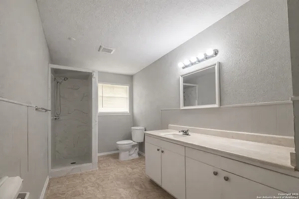 a bathroom with a double vanity sink toilet and shower