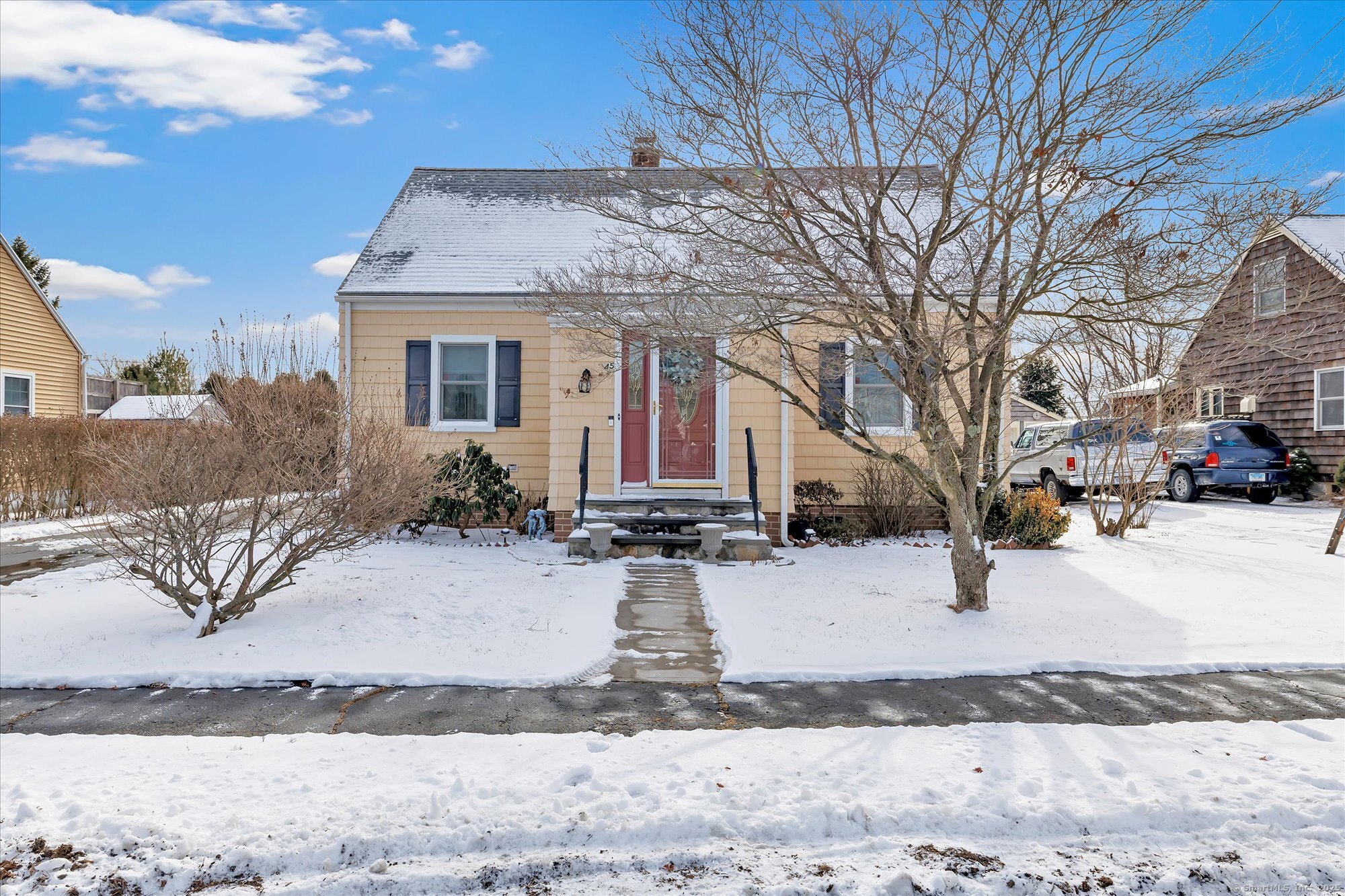 a view of a white house with a yard covered in snow