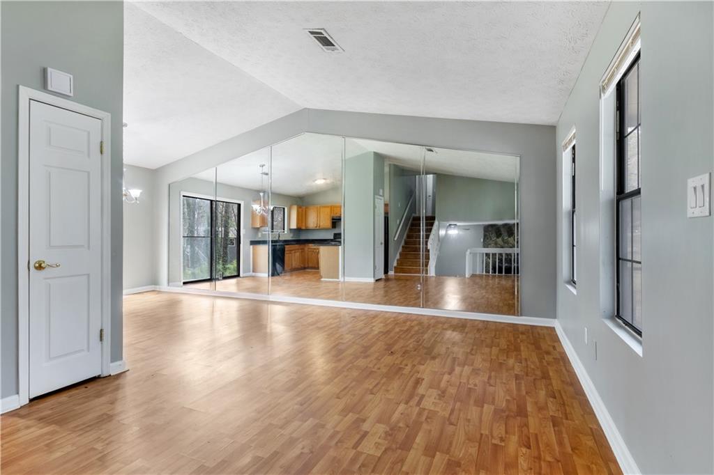 a view of a big room with wooden floor and a bathroom