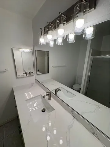 a bathroom with a sink a light fixture and a mirror