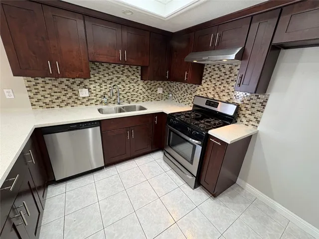 a kitchen with stainless steel appliances a cabinets and stove top oven
