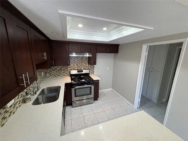 a kitchen with stainless steel appliances granite countertop a sink and a refrigerator