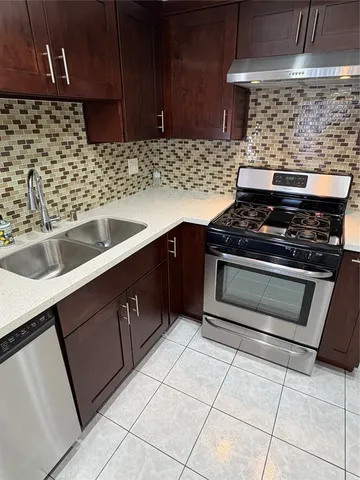 a kitchen with granite countertop a stove sink and cabinets