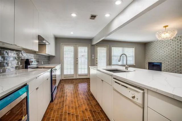 a kitchen with a sink a stove and cabinets