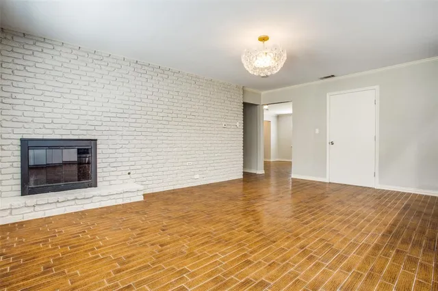 a view of empty room with wooden floor and fireplace