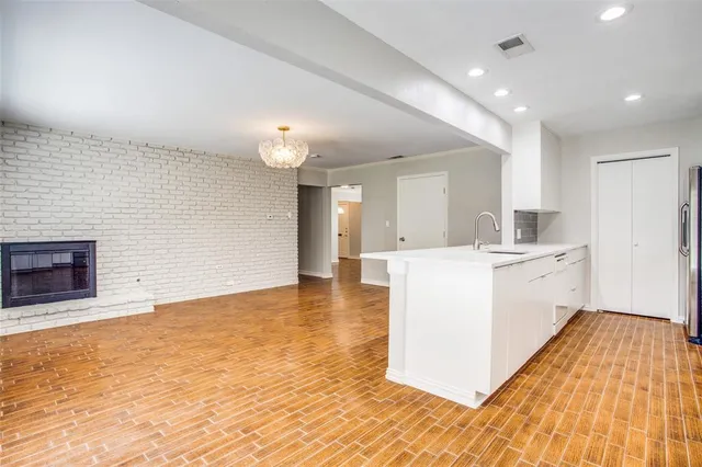 a large white kitchen with kitchen island a sink stainless steel appliances and cabinets