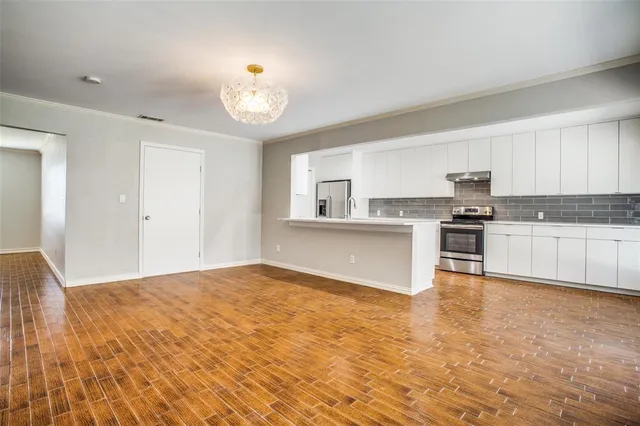 a large kitchen with cabinets and wooden floor