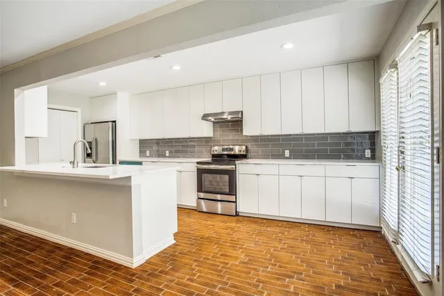 a kitchen with granite countertop white cabinets and white appliances