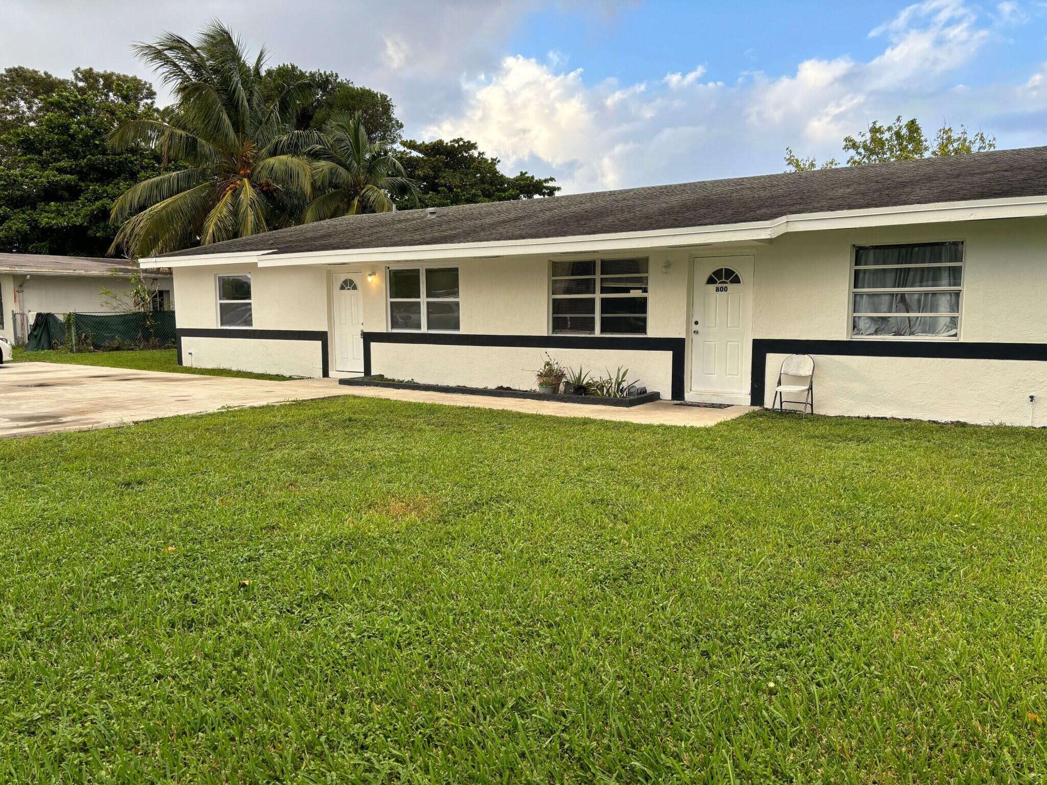 800 Southwest 7th Street Hallandale Beach, FL 33009 - Photo 3 of 9 a front view of house with yard and trees in the background