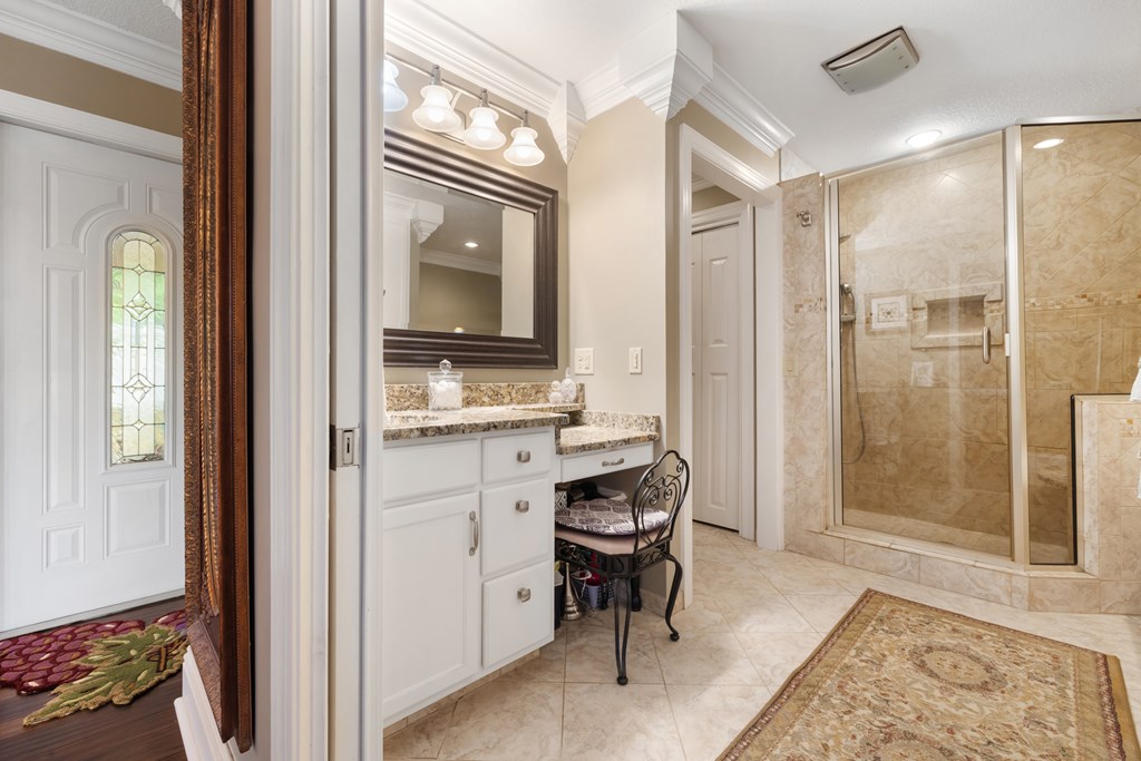 1396 Deerfield Road Young Harris, GA 30582 - Photo 34 of 60 a bathroom with a granite countertop sink a mirror and a shower