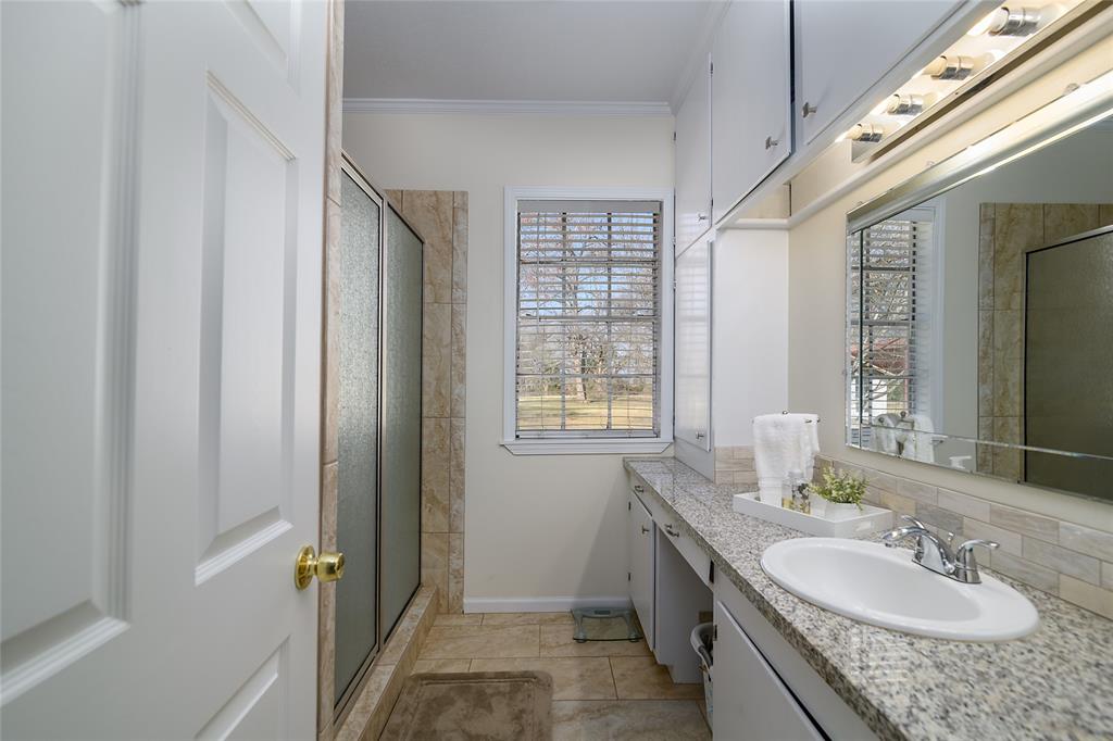 13040 Adger Road Gilliam, LA 71029 - Photo 19 of 29 a bathroom with a granite countertop double vanity sink a mirror and a shower
