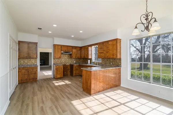 a kitchen with stainless steel appliances granite countertop a refrigerator and a stove top oven