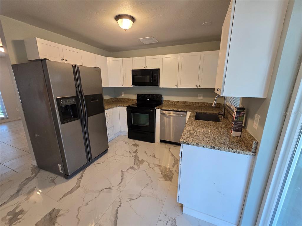 3406 Murrow Street New Port Richey, FL 34655 - Photo 10 of 21 a kitchen with stainless steel appliances granite countertop a refrigerator stove a sink and a oven