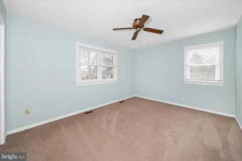 an empty room with a chandelier fan and a ceiling fan
