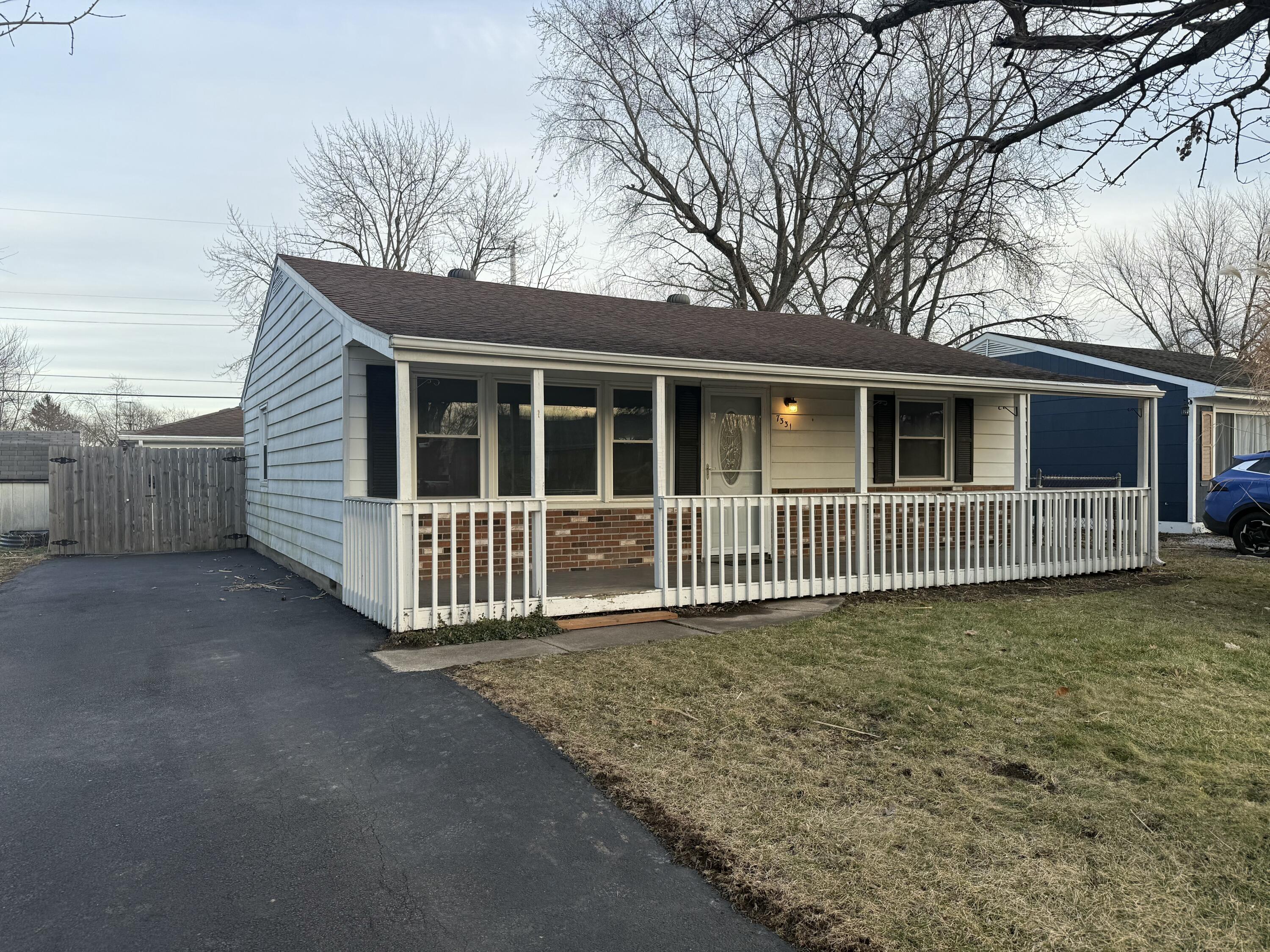 a view of a house with a small yard and wooden fence