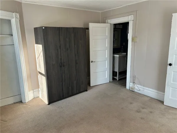 an empty room with closet and a window