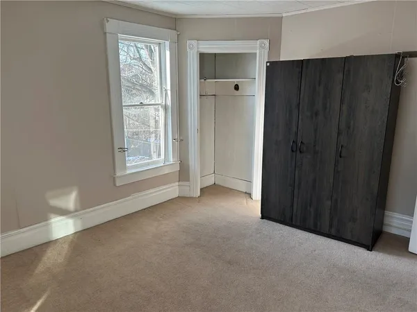 an empty room with windows and closet