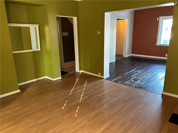 an empty room with wooden floor and closet