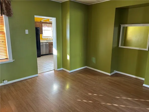 an empty room with wooden floor and closet