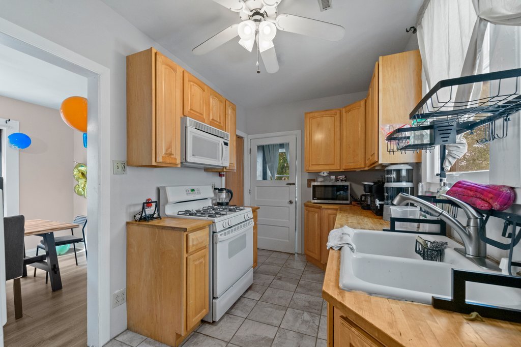 1224 Grove Avenue Berwyn, IL 60402 - Photo 9 of 23 a kitchen with stainless steel appliances granite countertop a sink a stove cabinets counter space and living room view