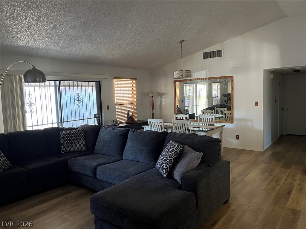 6412 West Pearcrest Road Las Vegas, NV 89108 - Photo 5 of 17 An open concept living and dining area boasts vaulted ceilings and rich wood flooring.
