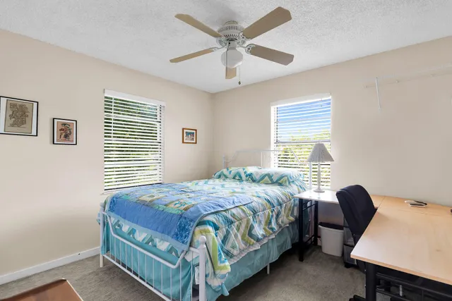 a bedroom with a bed window and a desk
