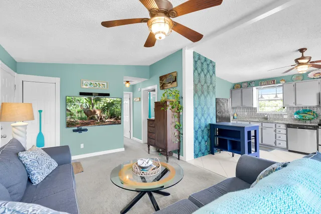 a living room with furniture kitchen view and a large window