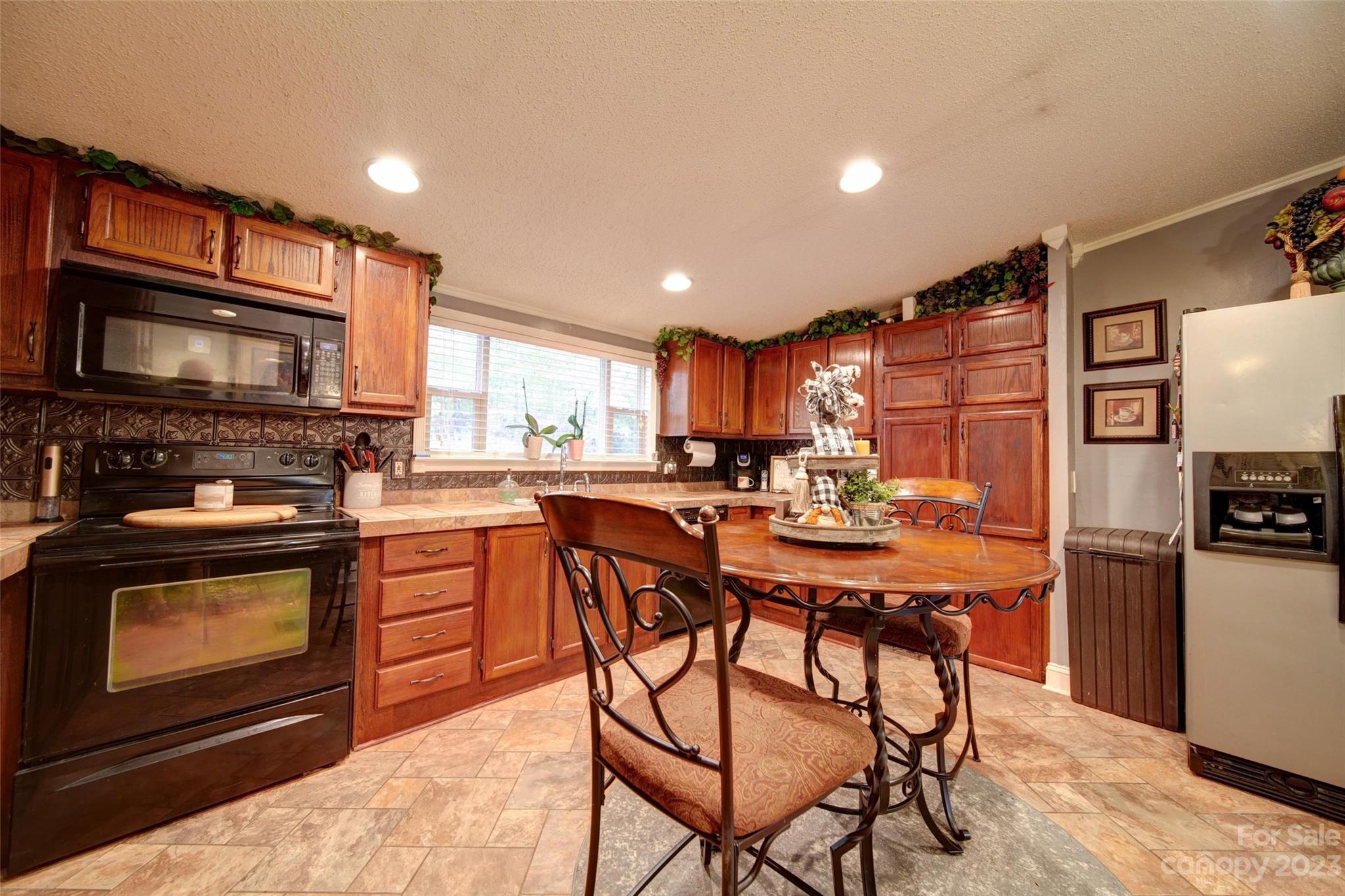 86 Edwards Store Road Peachland, NC 28133 - Photo 6 of 20 a kitchen with stainless steel appliances granite countertop a stove a sink dishwasher a microwave oven and a refrigerator with wooden cabinets