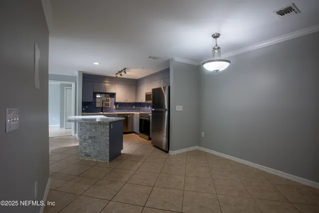 a kitchen with refrigerator and cabinets