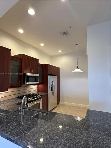 a kitchen with stainless steel appliances a refrigerator and a stove top oven