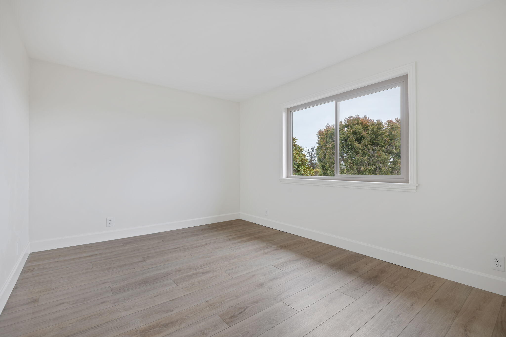 5930 Via Real, Unit 3 Carpinteria, CA 93013 - Photo 14 of 25 a view of an empty room with wooden floor and a window