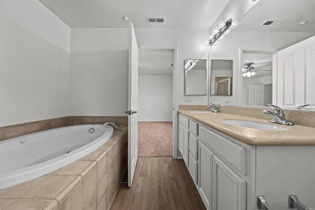 a bathroom with a tub sink and mirror