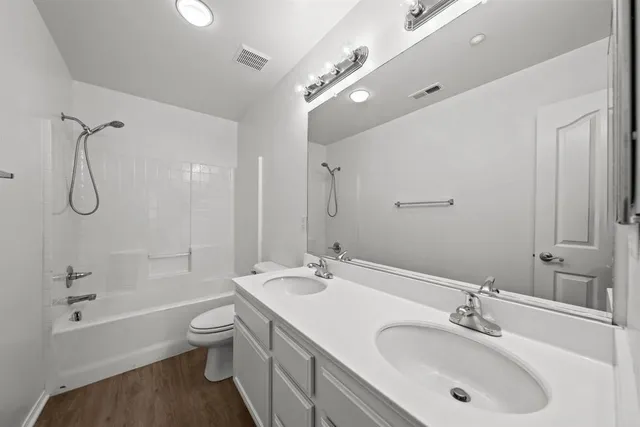 a bathroom with a granite countertop sink a toilet and shower